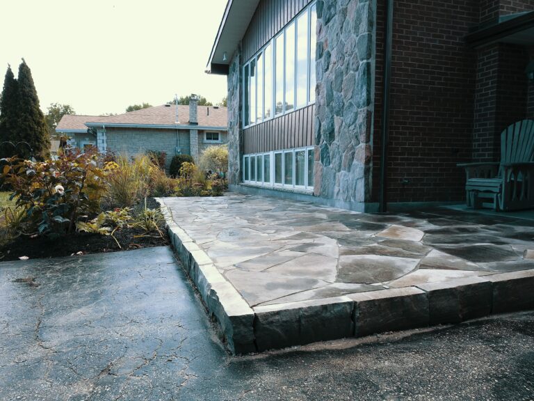 Raised flagstone patio with native garden in Meaford by EcoCultures