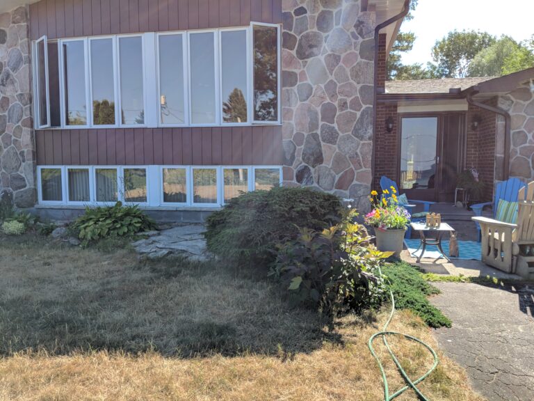 Raised flagstone patio with native garden in Meaford by EcoCultures