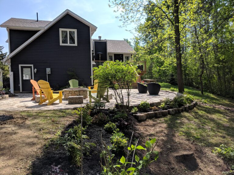Flagstone patio with fire pit, retaining wall, and native gardens in Blue Mountains by EcoCultures