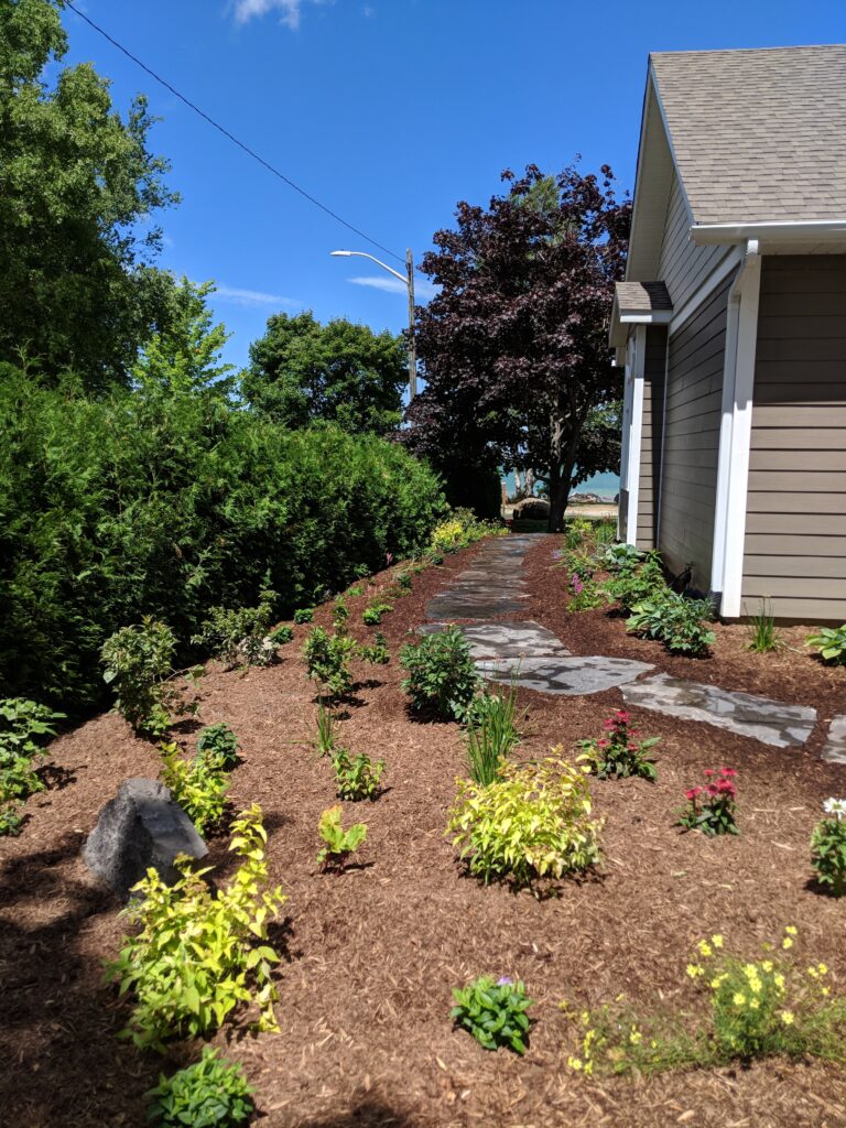 Stepping stone walkway with patio and attractant garden in Meaford by EcoCultures