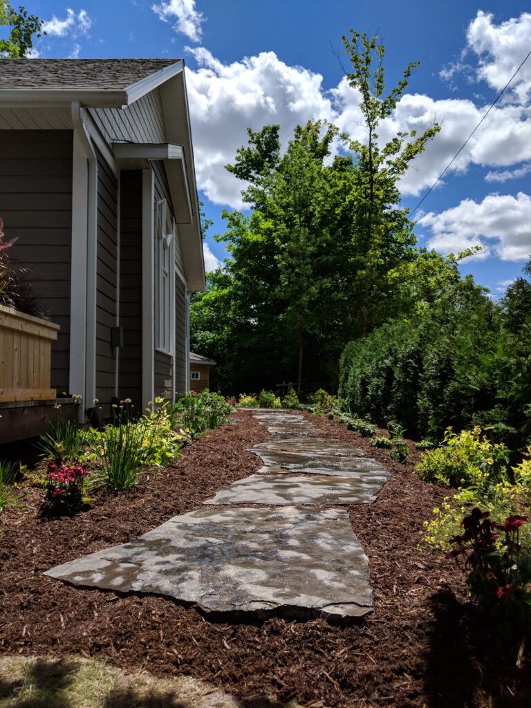 Stepping stone walkway with patio and attractant garden in Meaford by EcoCultures